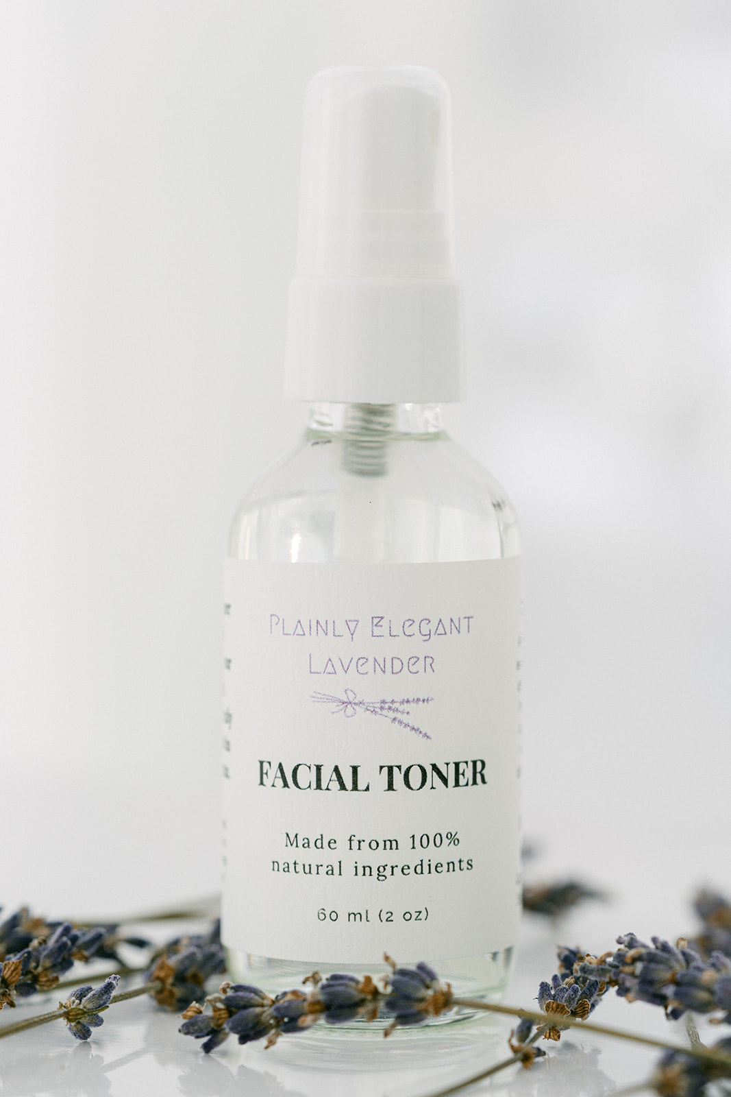 Facial toner bottle with lavender flowers on a white background