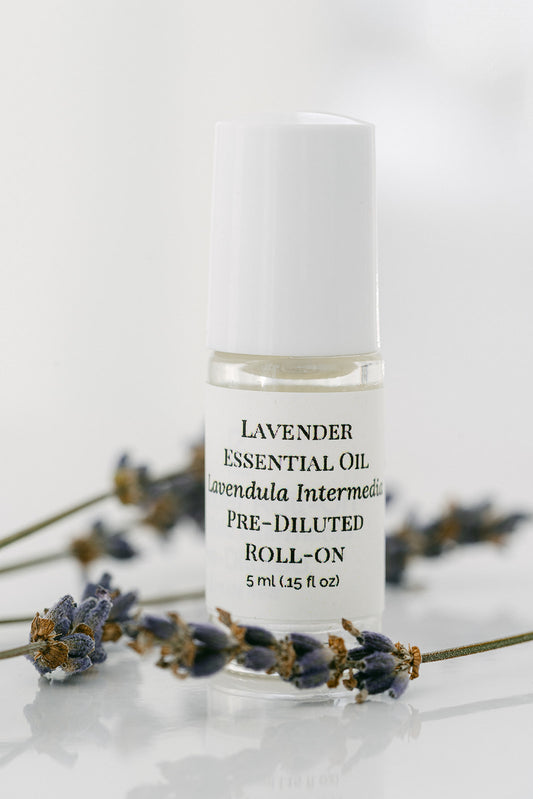 Roll-on bottle of lavender essential oil with lavender flowers on a light background